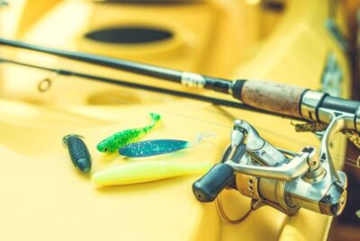 A fishing rod on a yellow kayak, a fishing kayak accessory.